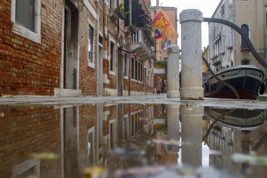 Velencei tócsában tükröződik az utca és a hajók